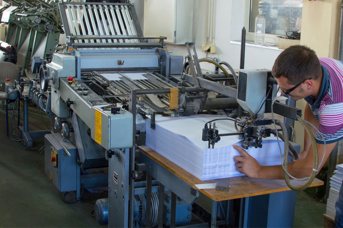 Man printing business card through printing machine