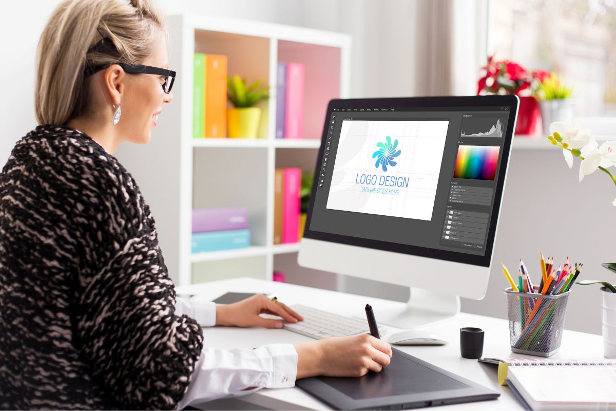 Woman designing a logo on desktop by using vector file