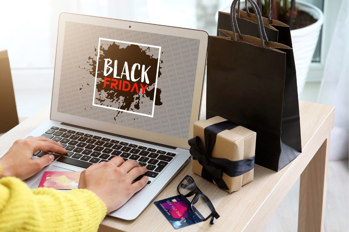 A laptop on the table displaying 'Black Friday' alongside a gift box