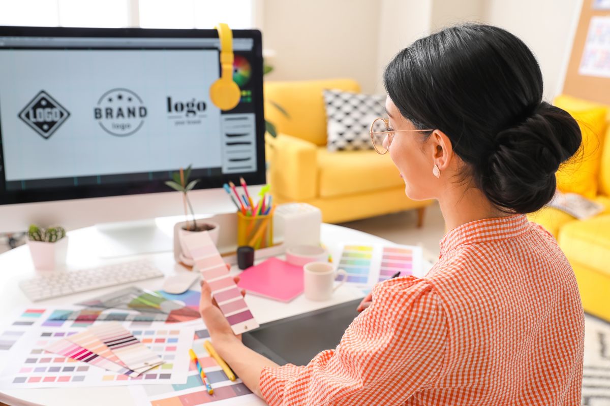 A woman designs a logo on her computer exploring low cost high profit business ideas