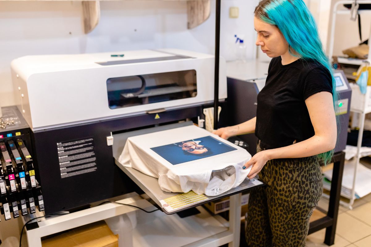 A woman prints a T shirt using DTG printing Method