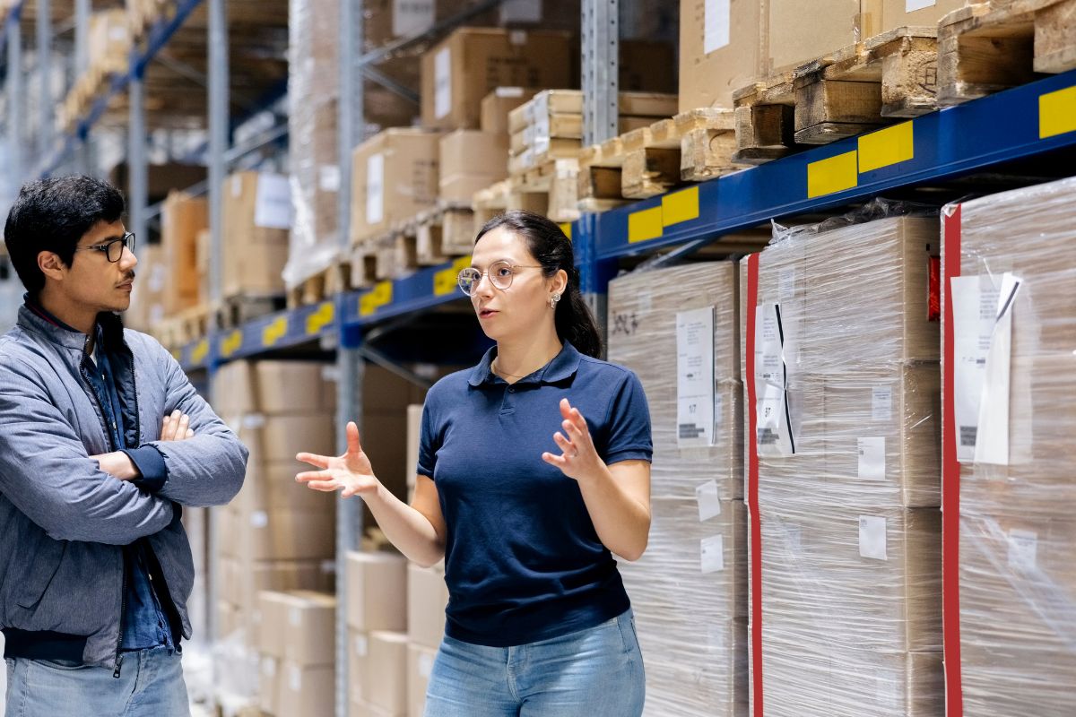 Woman and man discuss dropshipping strategies in a warehouse