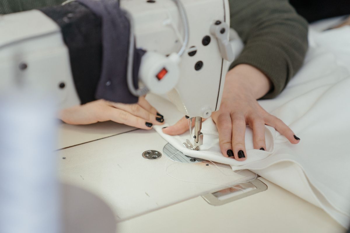 A lady sewing t shirt with the help of sewing machine