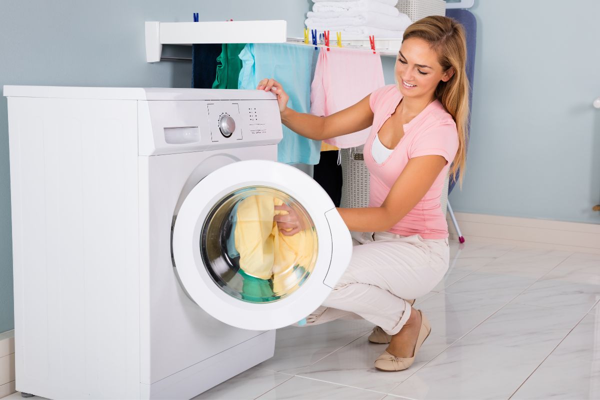 A lady washing printed T shirts in washing machine