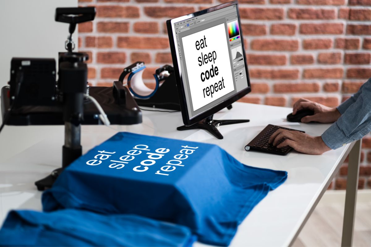 A man designs t shirts while working on his desktop