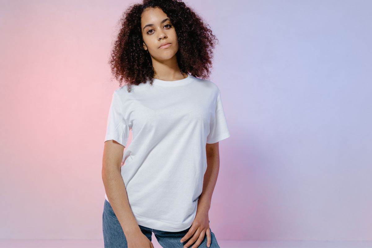A woman proudly showcases her white crew neck t shirt