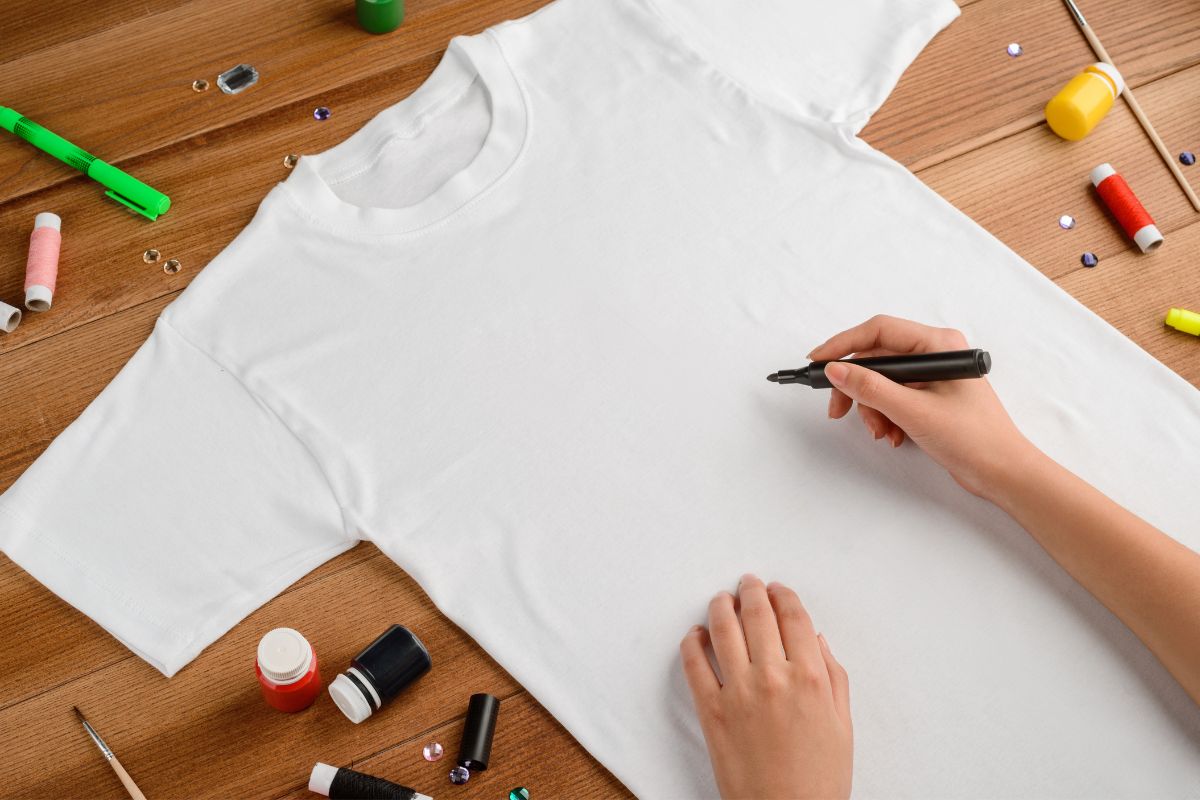 Woman drawing on a blank t shirt with a fabric marker