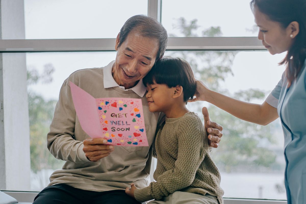 A little boy giving his grandfather a card of Get Well Soon