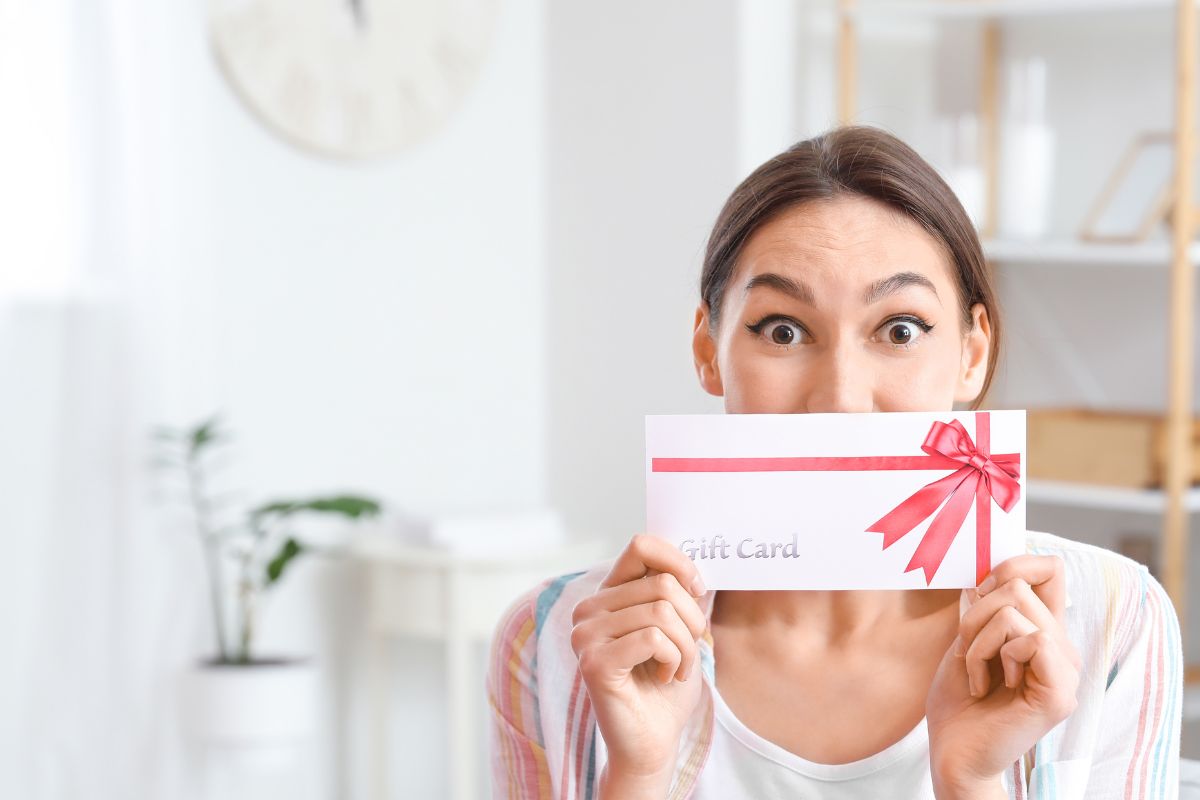 A nurse holding a gift card in her hand