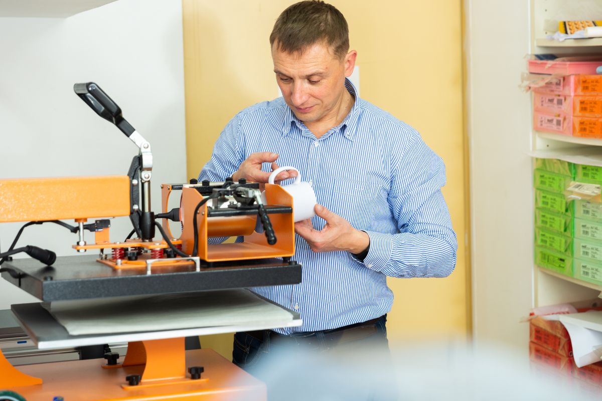 A person printing personalized mugs for the nurses at the workshop