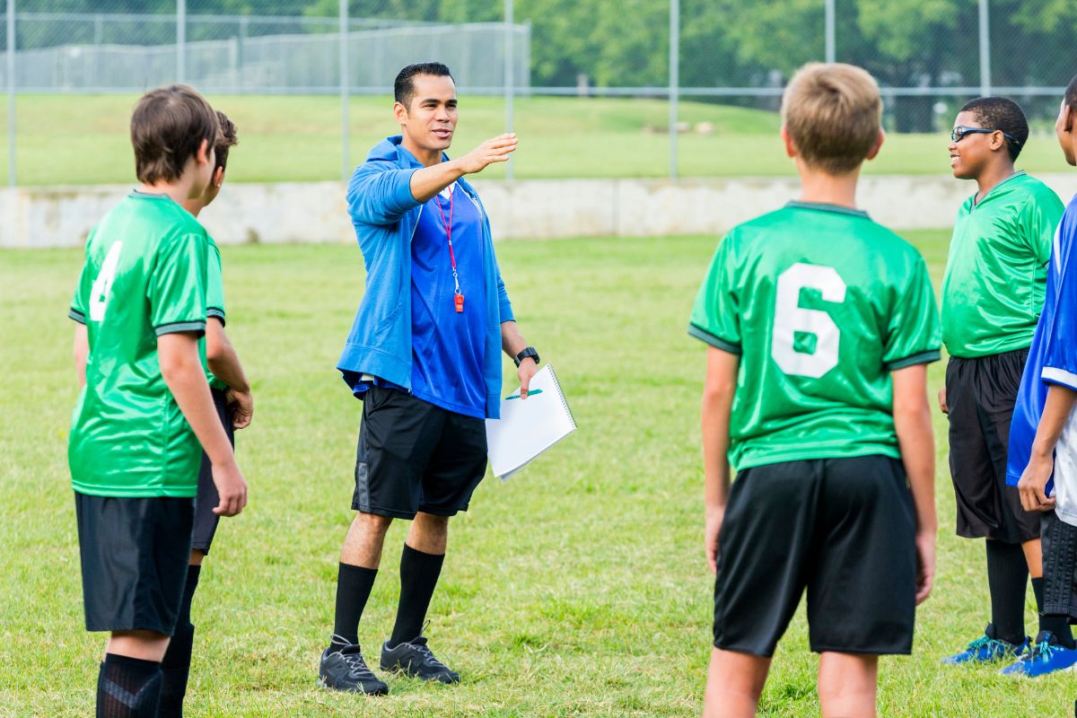 Sports coach talking to his team wearing a uniform