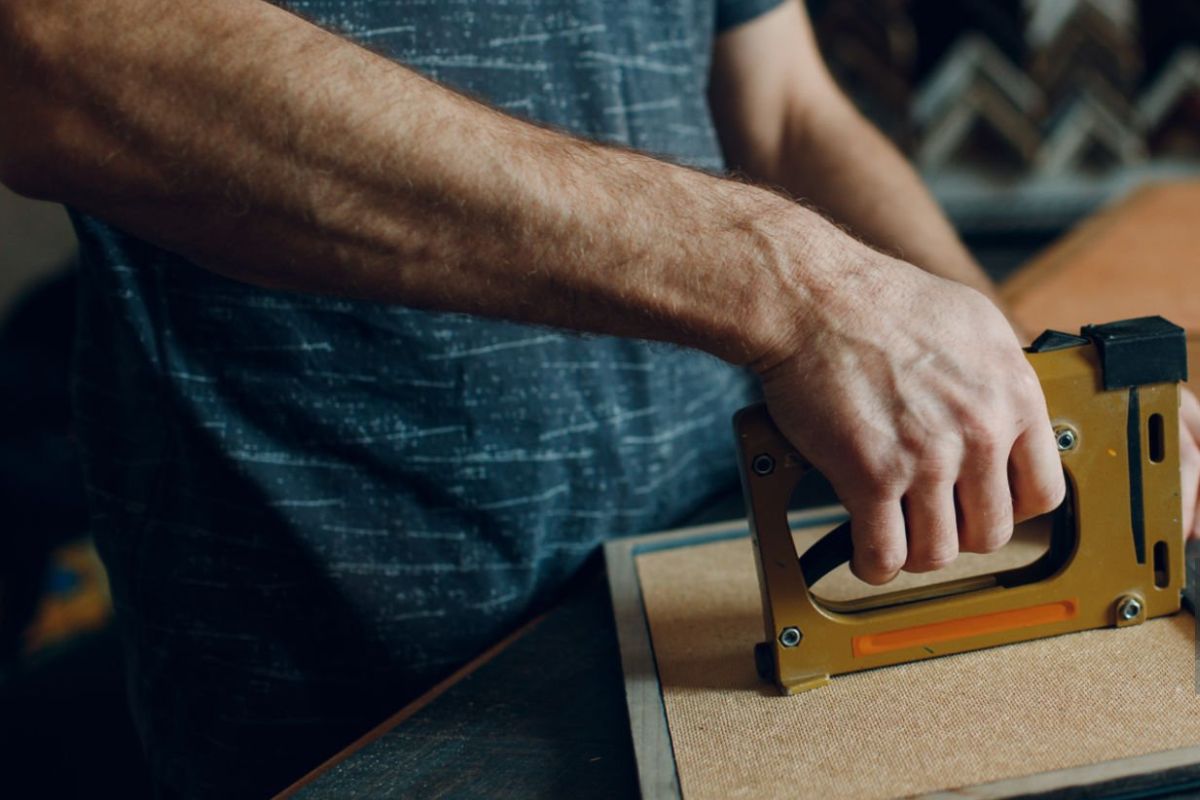 A person Assembling photo frame with a tool.