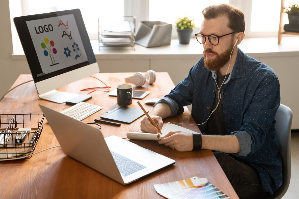 A person designing logo for a merchandise business owner.