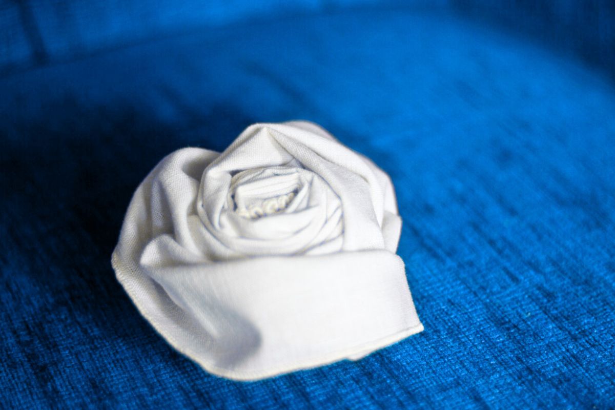 A rose fold napkin design shown in the image.